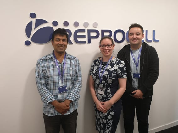 Image showing three smiling scientists standing in front of a REPROCELL sign