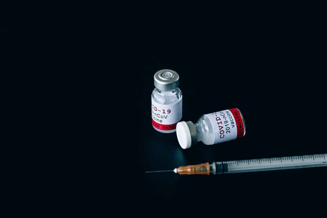 Image showing two covid vaccine vials sitting next to a syringe 