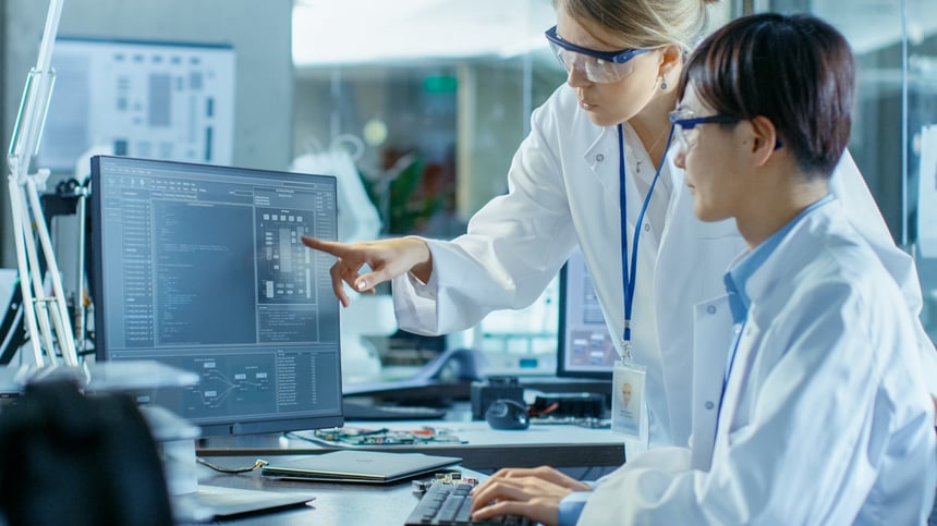 Two scientists discussing results on a computer Adobe stock 