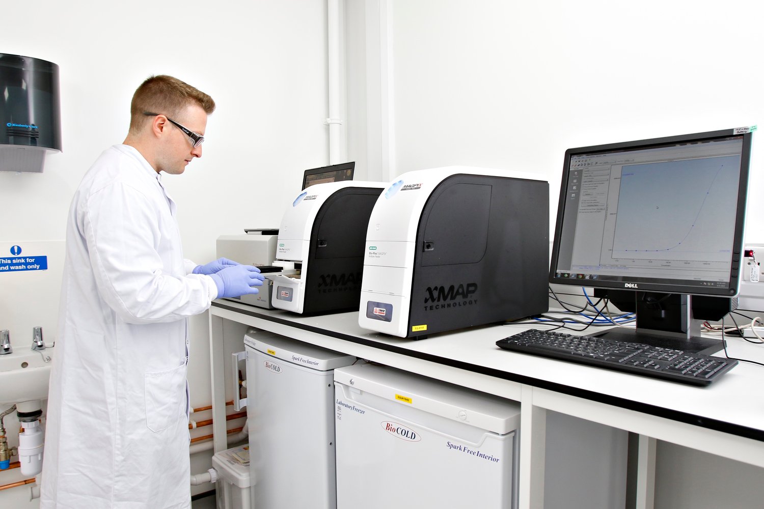 Scientist loading a plate into a luminex instrument