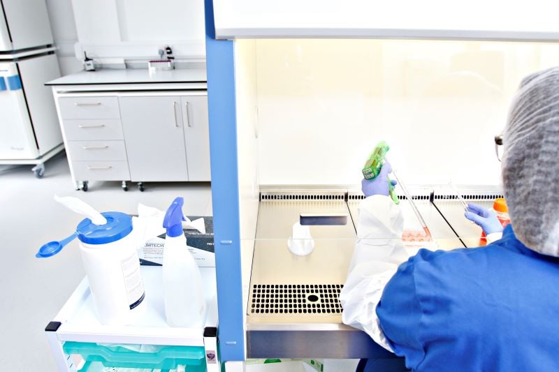 Image showing a scientist working in a fume hood using a pipette 